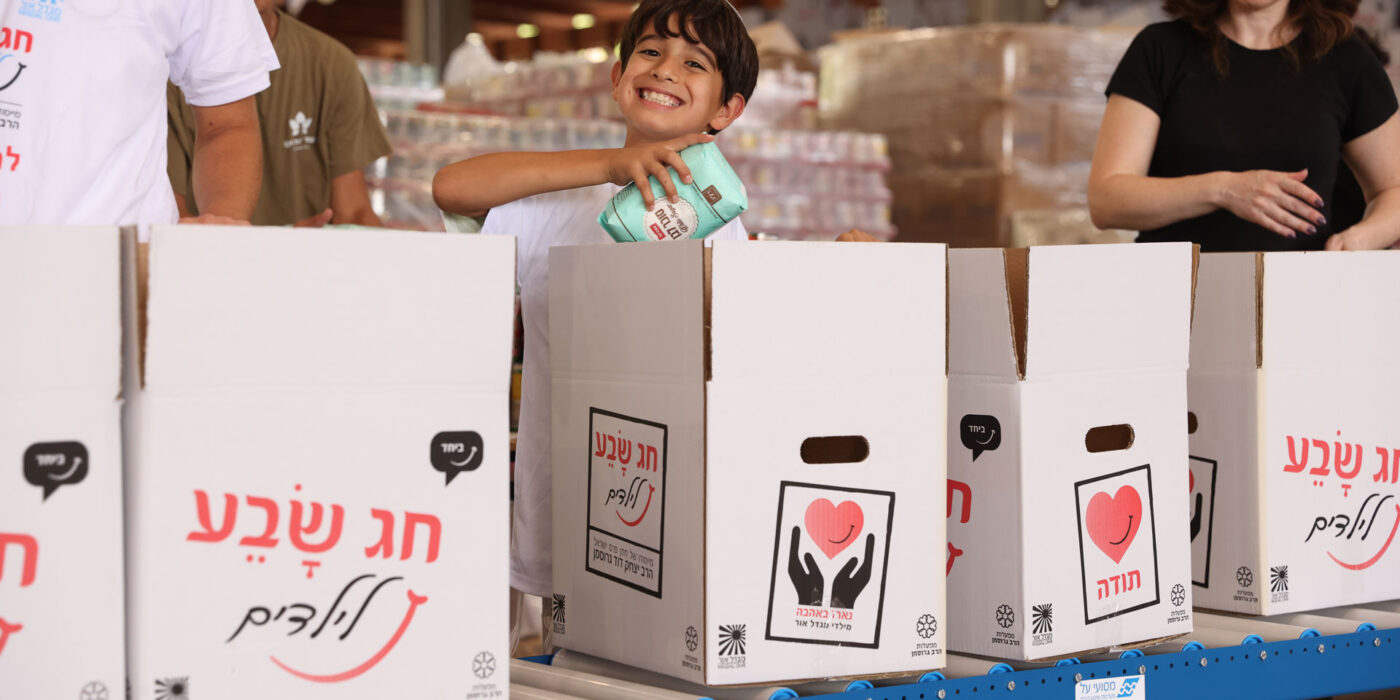 ילד אורז חבילות מזון לנזקקים