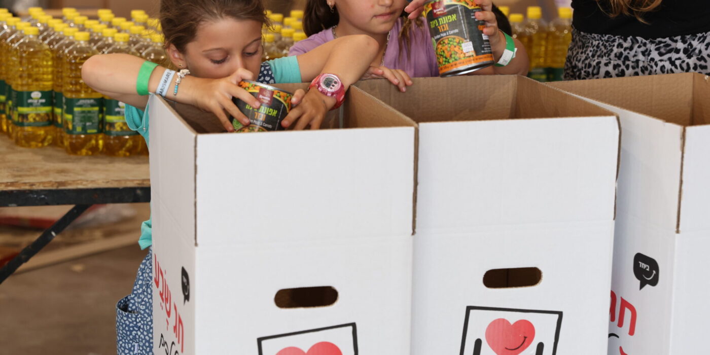 ילדות מכניסות מוצרי מזון לארגז