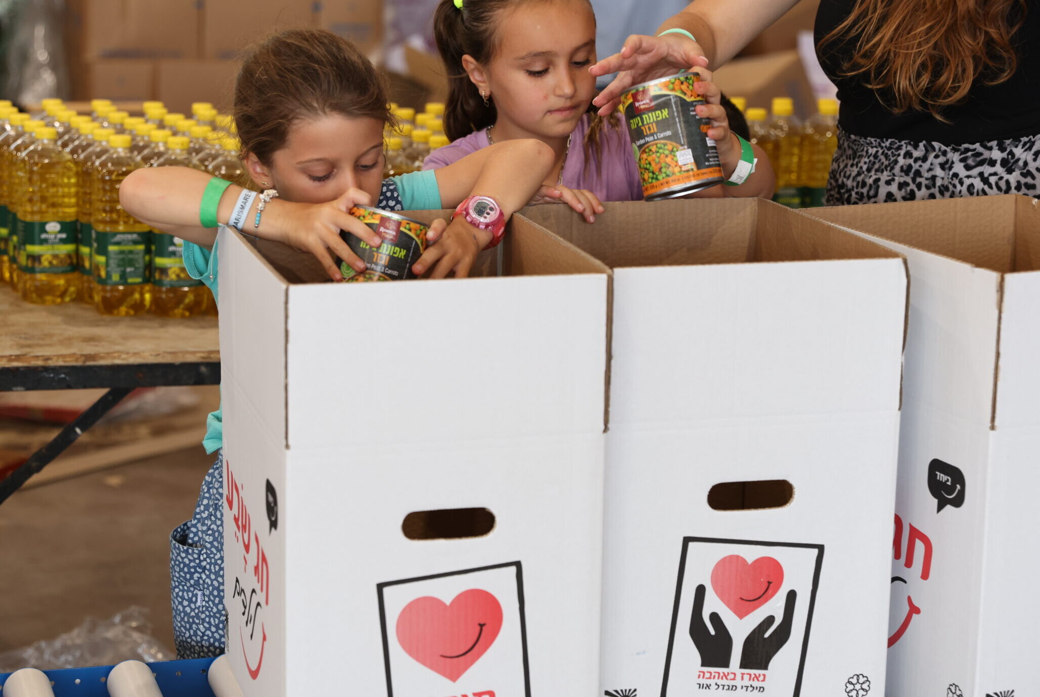 ילדות מכניסות מוצרי מזון לארגז
