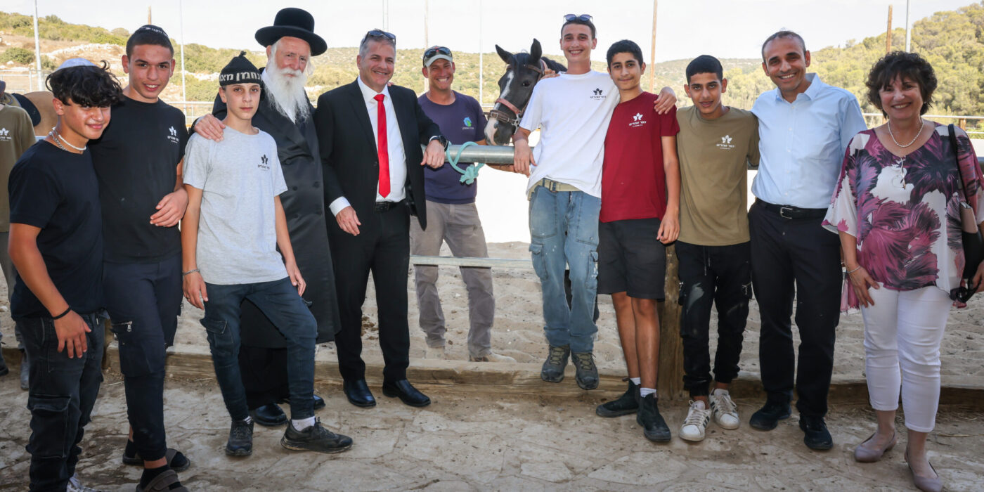 יואב קיש, הרב גרוסמן ותלמידי זוהרים על רקע חוות סוסים