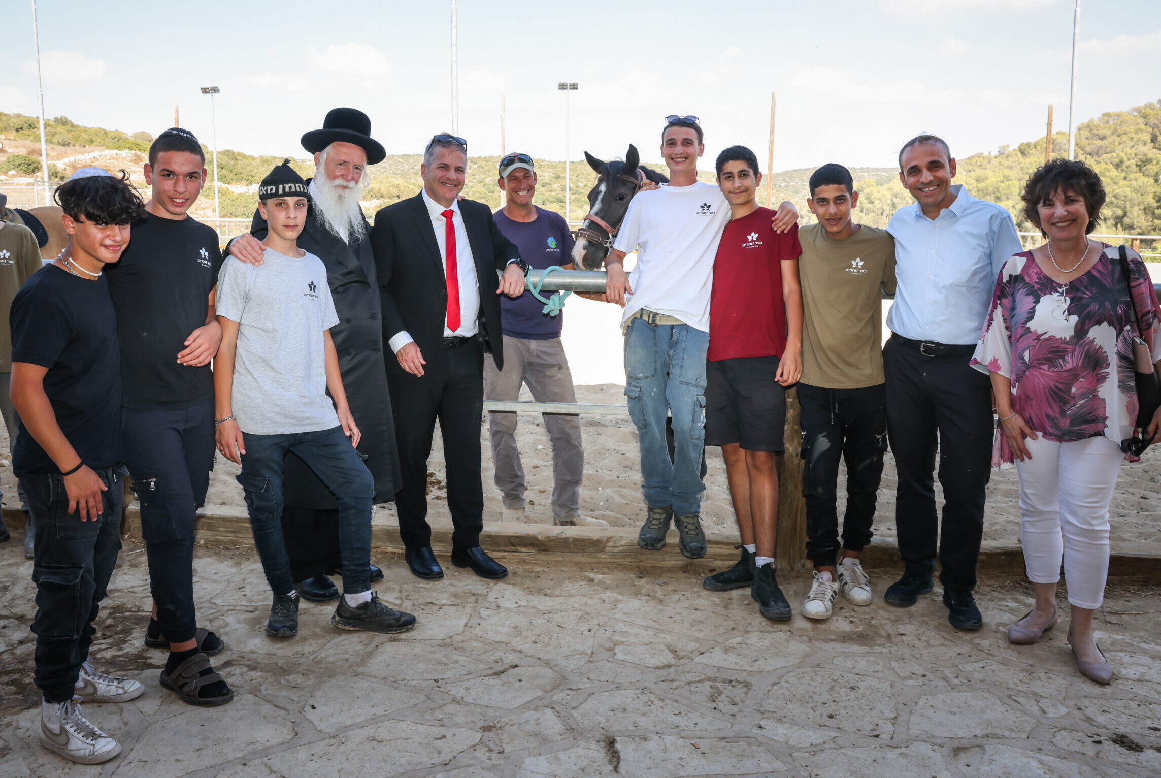 יואב קיש, הרב גרוסמן ותלמידי זוהרים על רקע חוות סוסים