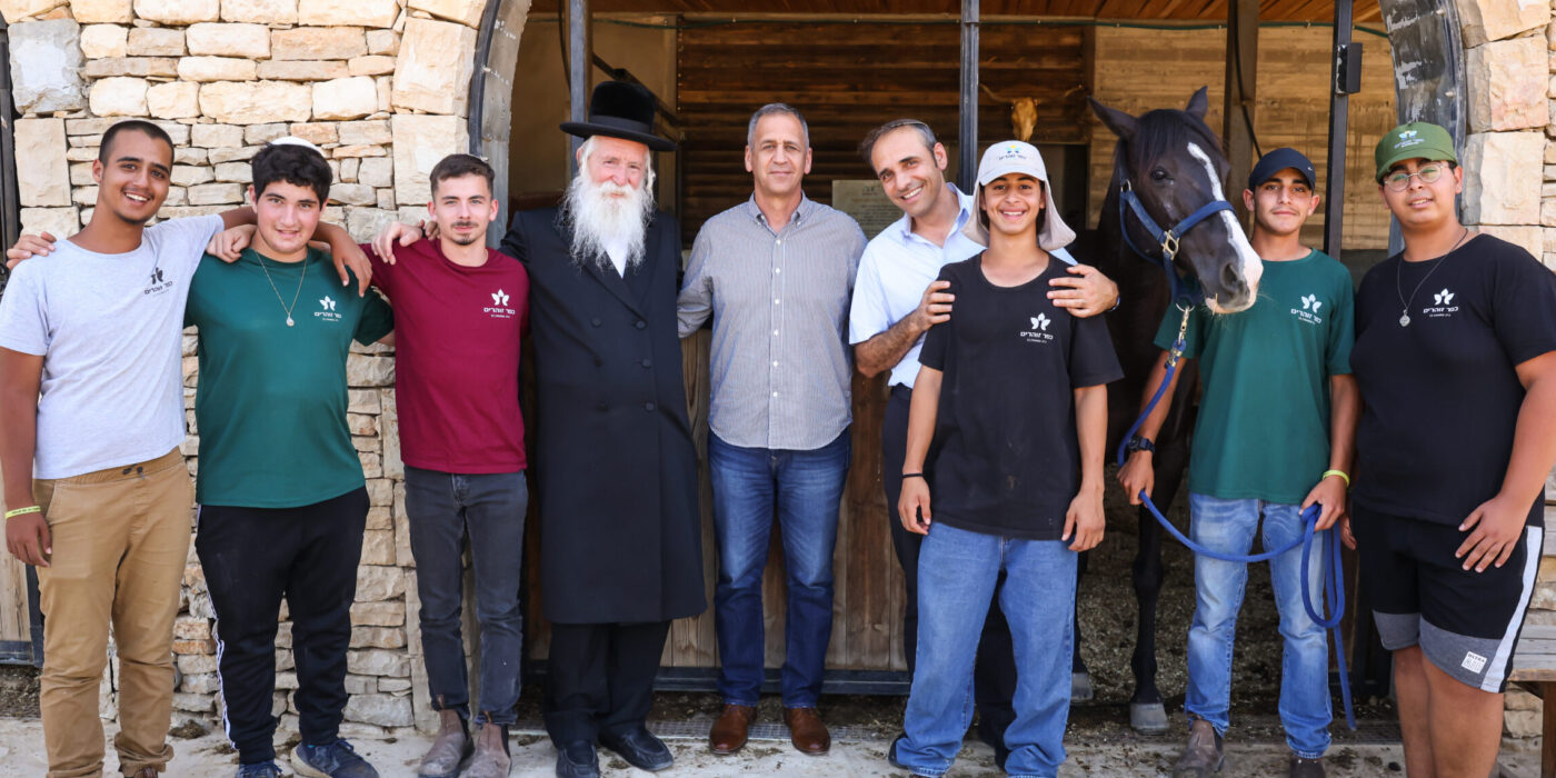 אביב כוכבי עם תלמידי הכפר על רקע חוות הסוסים