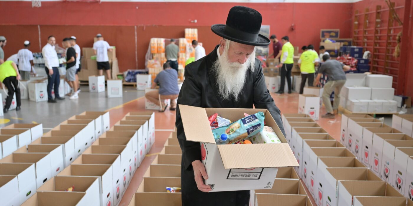 הרב גרוסמן אורז יחד עם חניכי תנועת הנוער אור ישראלי חבילות מזון