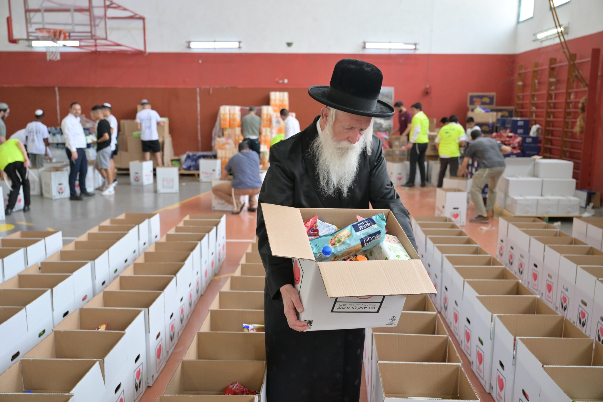 הרב גרוסמן אורז יחד עם חניכי תנועת הנוער אור ישראלי חבילות מזון