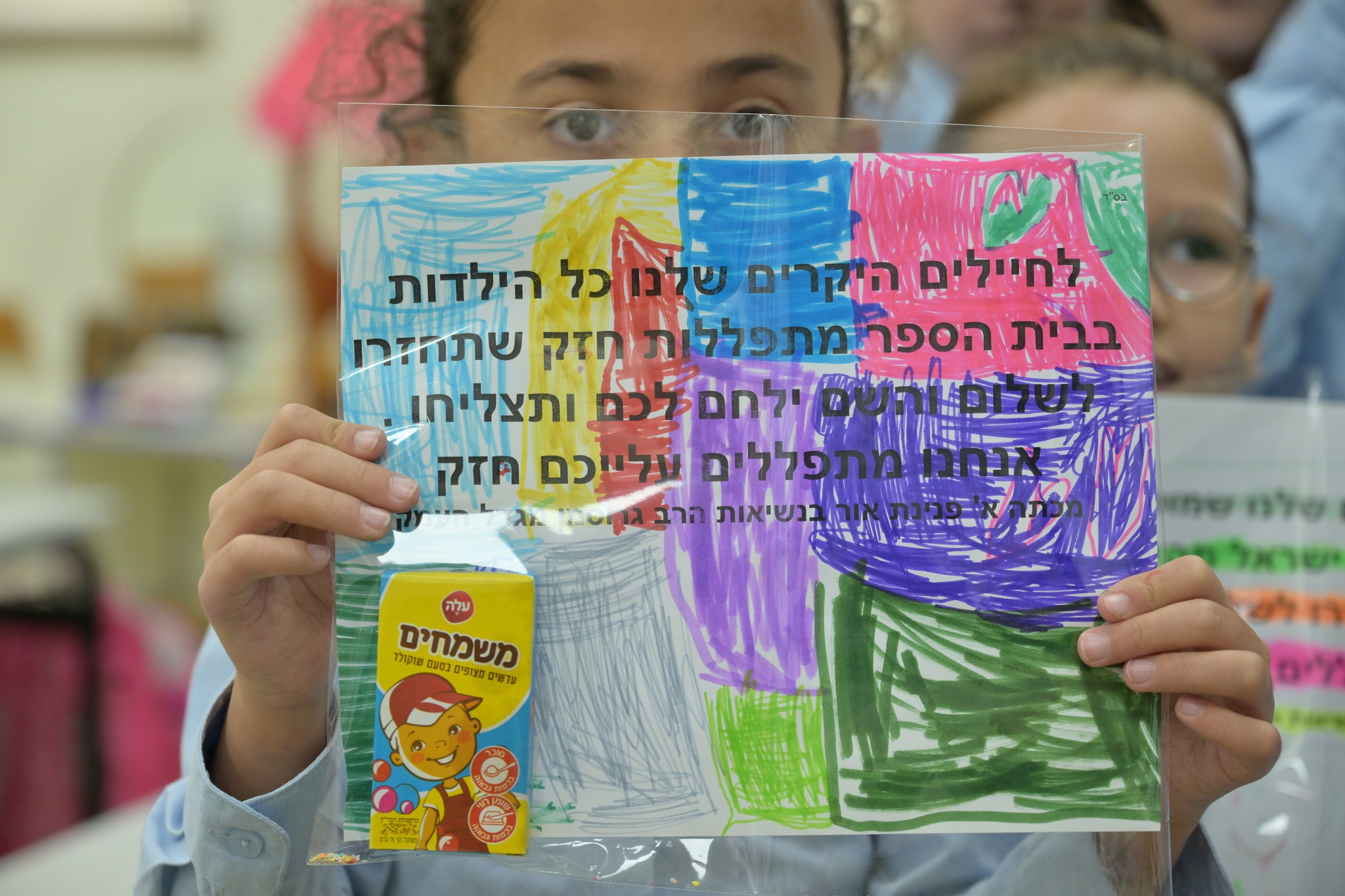 תלמידה מחזיקה ברכה לחייל