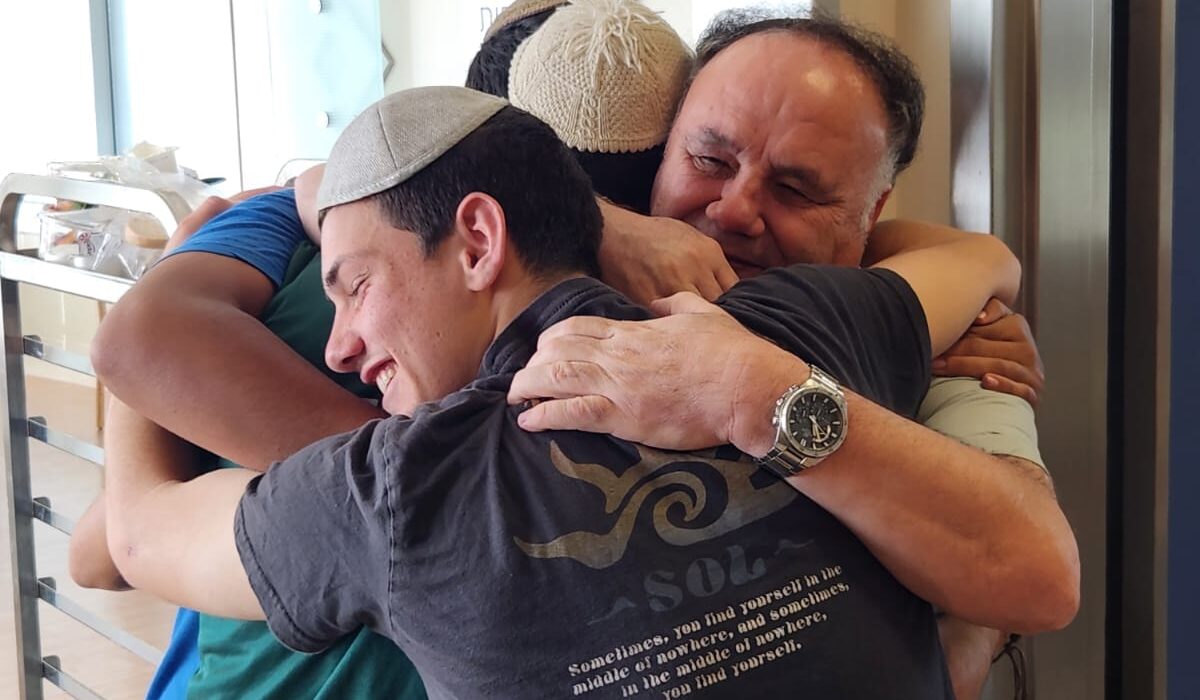 תלמידי זוהרים מחבקים אב של חייל פצוע