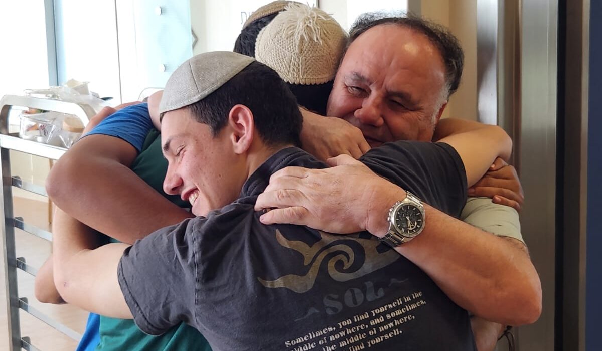 תלמידי זוהרים מחבקים אב של חייל פצוע
