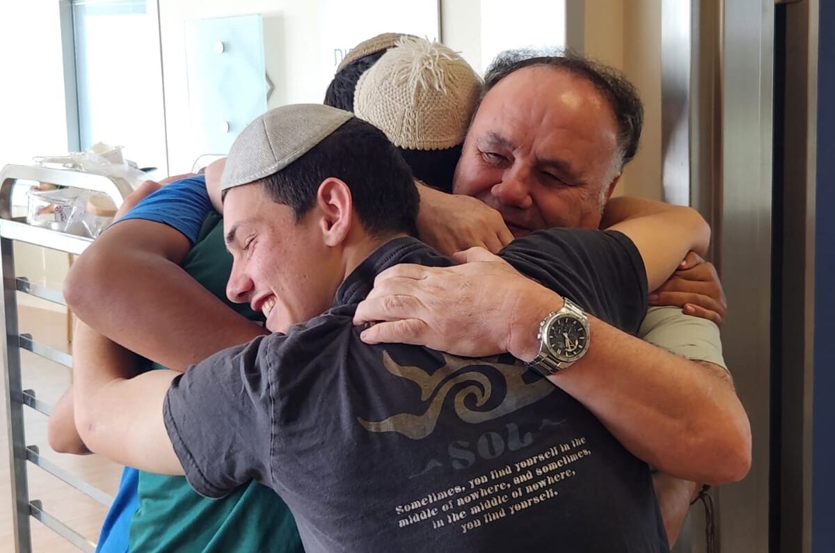 תלמידי זוהרים מחבקים אב של חייל פצוע