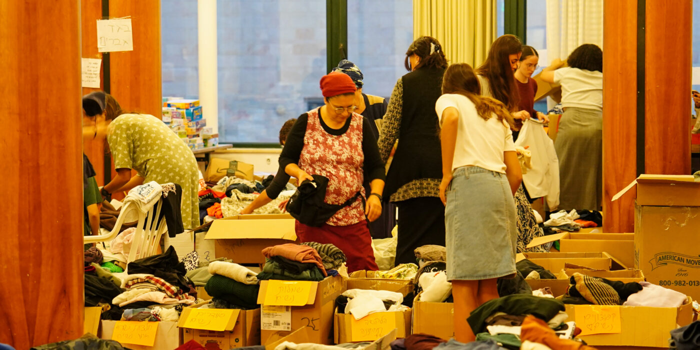 נשים מפונות מחפשות בגדים שנתרמו בארגזים