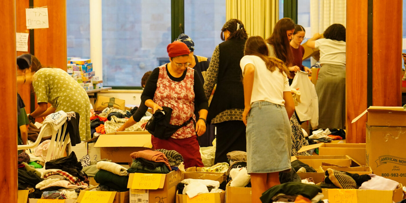 נשים מפונות מחפשות בגדים שנתרמו בארגזים