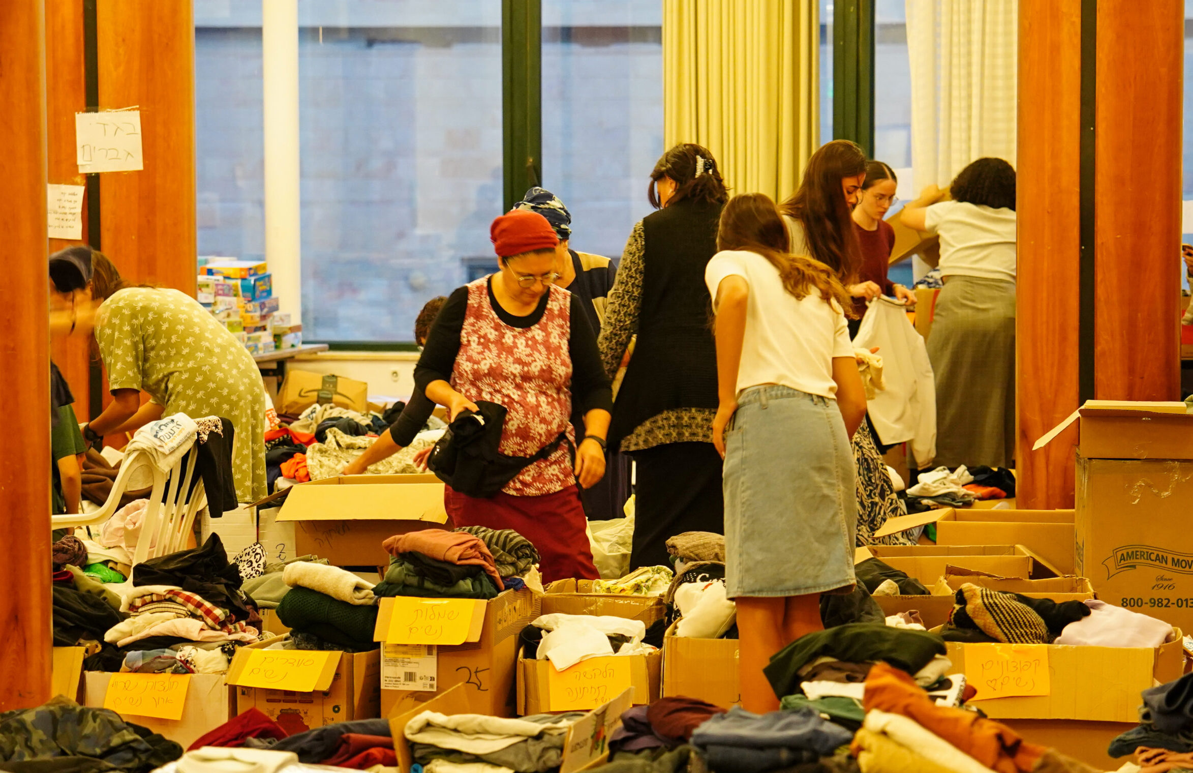 נשים מפונות מחפשות בגדים שנתרמו בארגזים