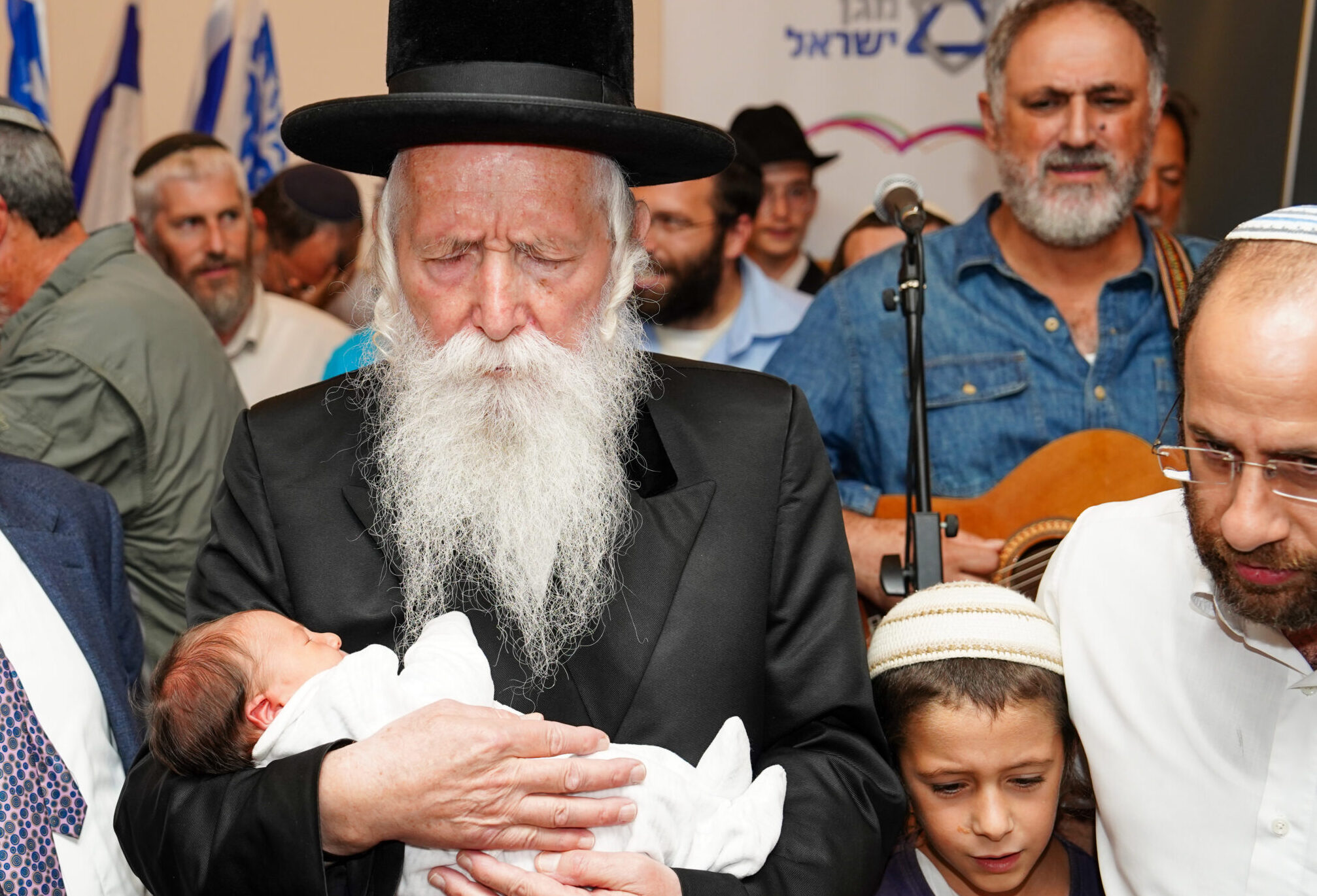 הרב גרוסמן אוחז תינוטק בטקס ברית