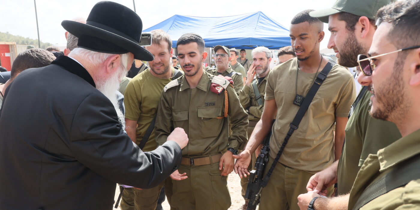 הרב גרוסמן מחלק מטבעות לחיילים